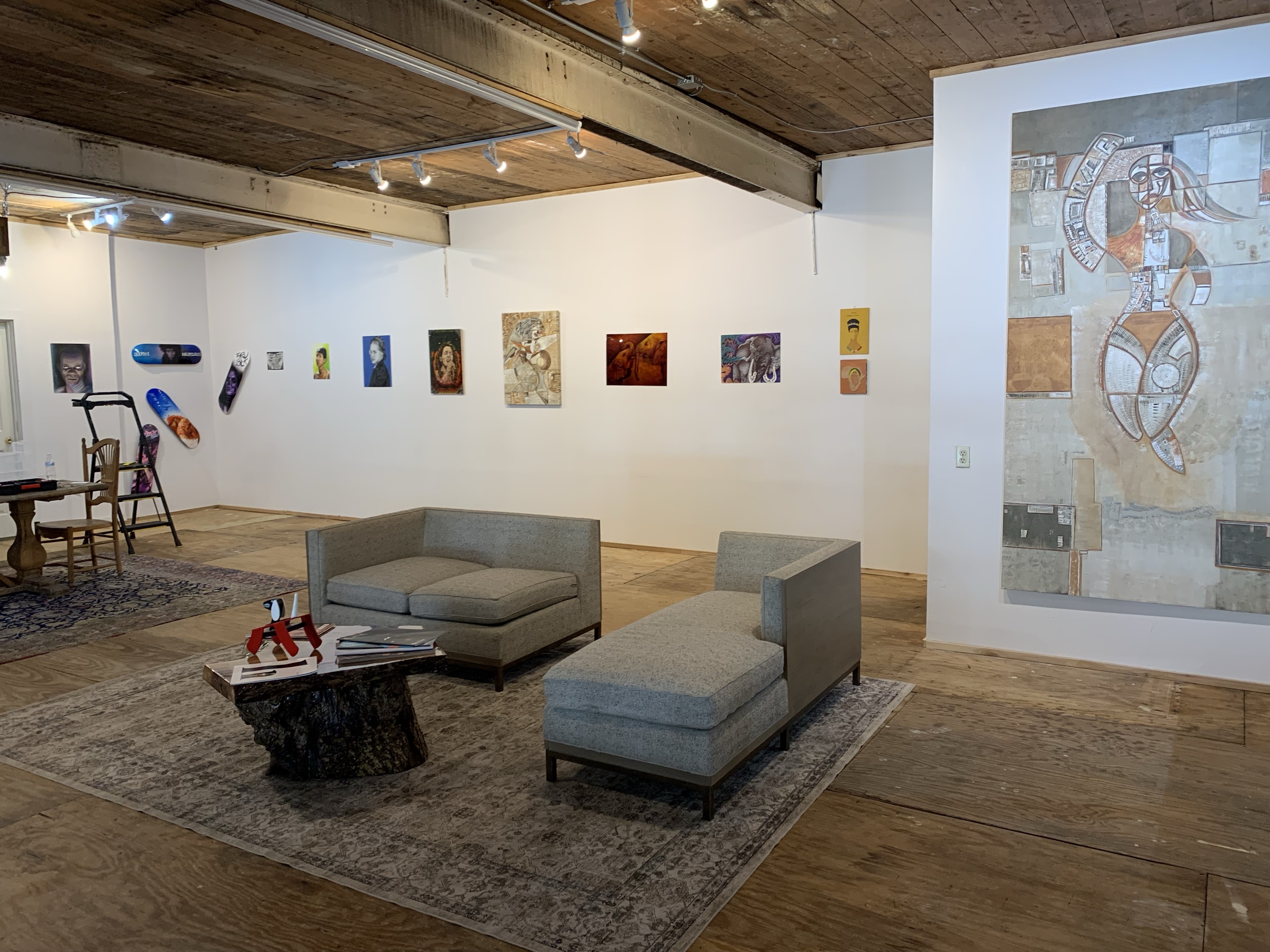 Be Free Gallery interior — paintings on the wall and lounge seating